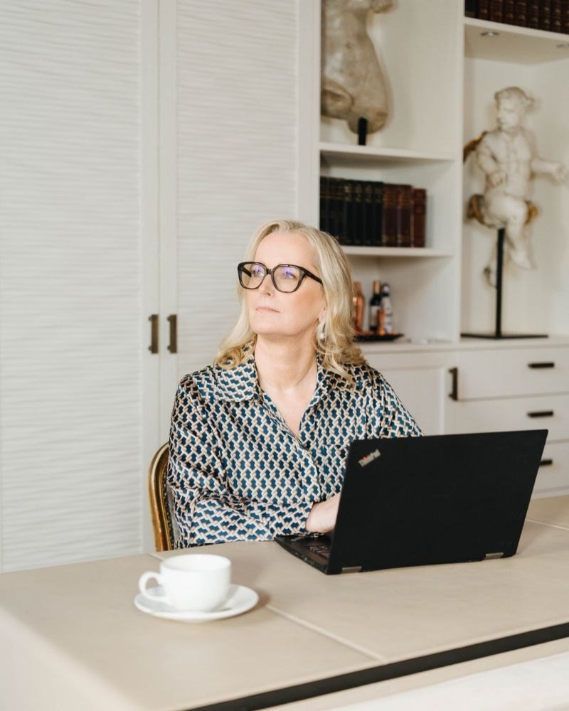 Marina Adrian sitzt am Laptop und schaut nachdenklich zur Seite