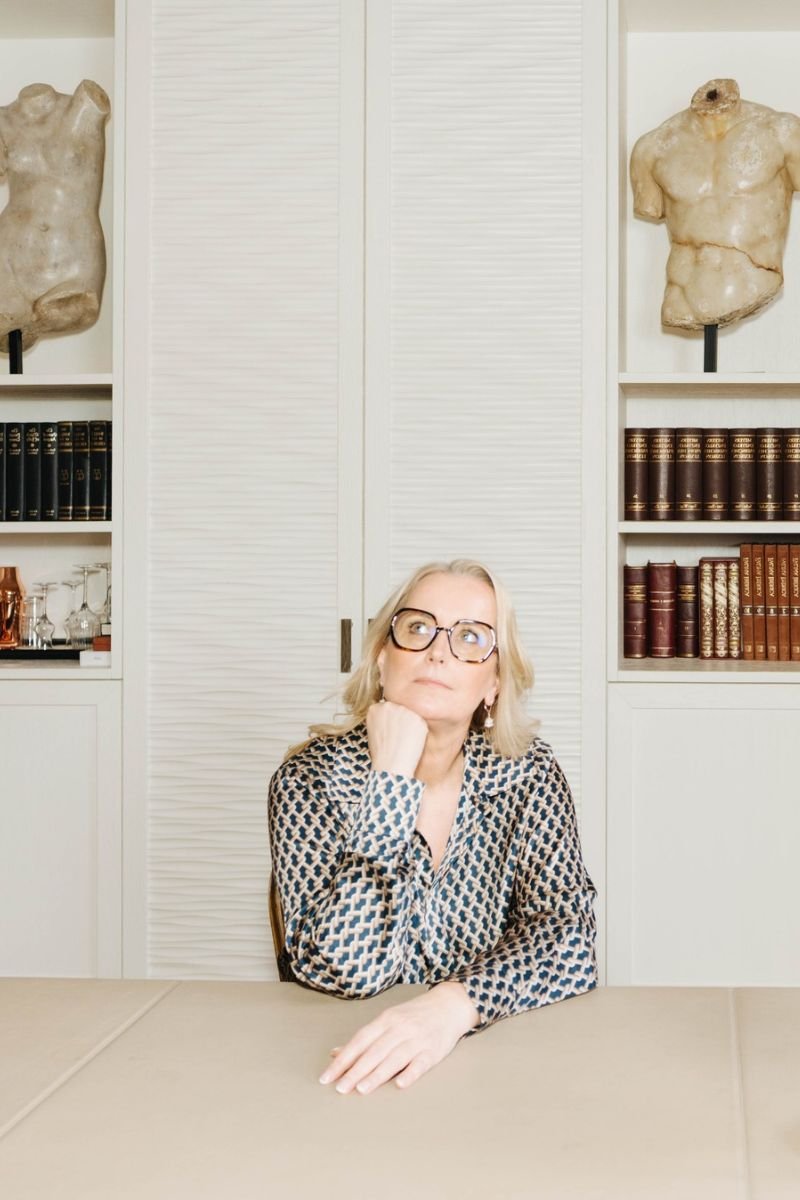 Marina Adrian sitzt nachdenklich am Tisch und schaut nach oben